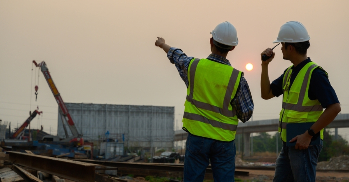 An architect and a builder talk on a construction site