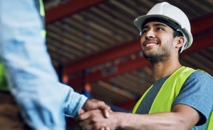 Two construction workers shake hands building a career