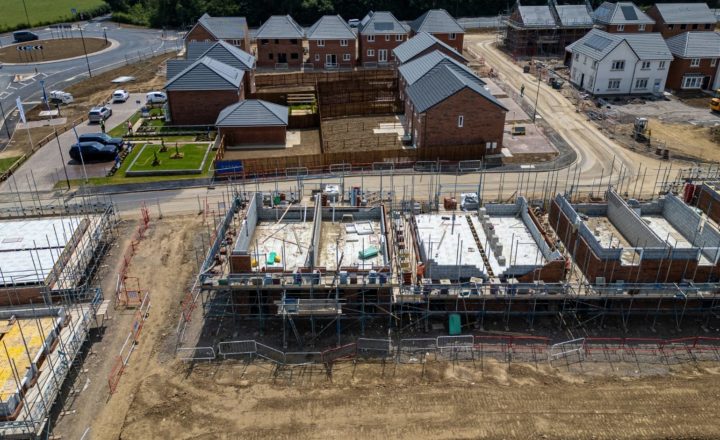 Construction industry growth New housing development under construction in the UK with brick houses, scaffolding and roads forming a growing estate