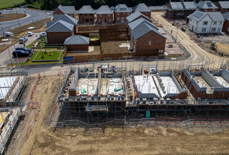 Construction industry growth New housing development under construction in the UK with brick houses, scaffolding and roads forming a growing estate