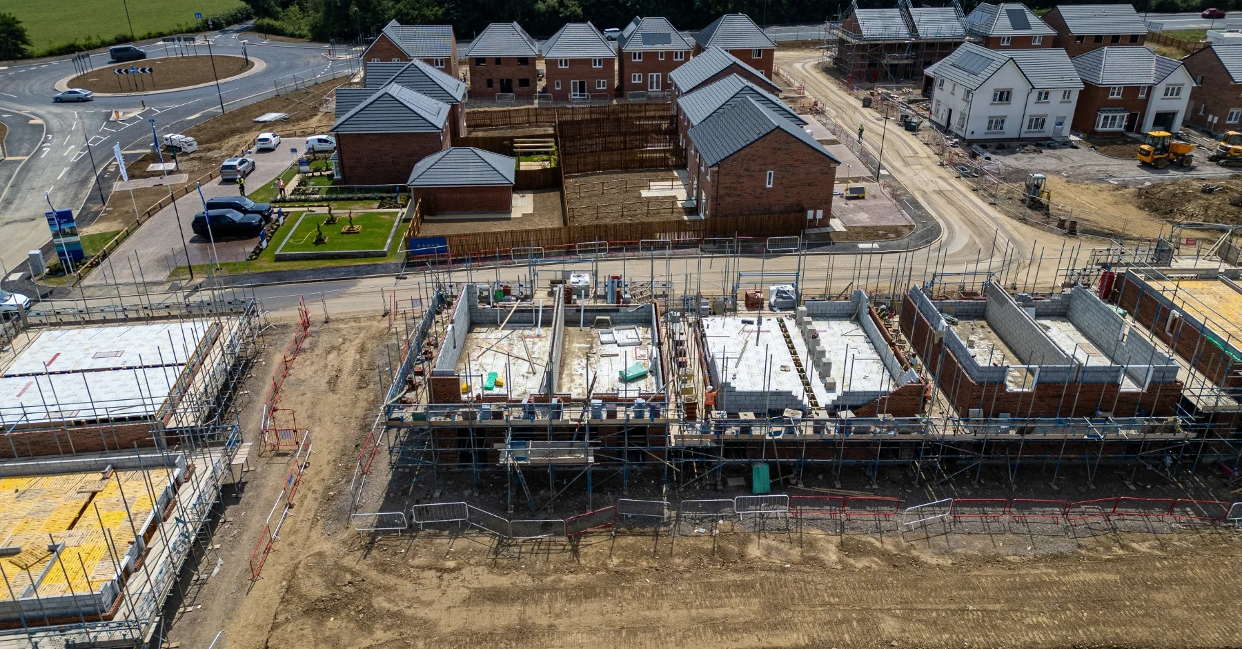 Construction industry growth New housing development under construction in the UK with brick houses, scaffolding and roads forming a growing estate