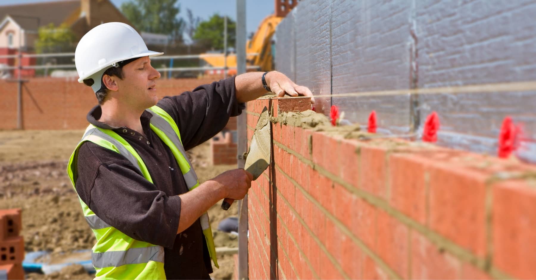 Bricklayer on a construction project using skills developed through staff training.