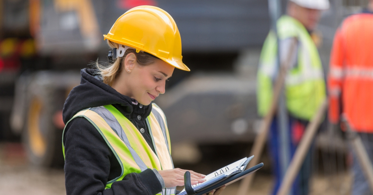 A female construction worker consults a clipboard