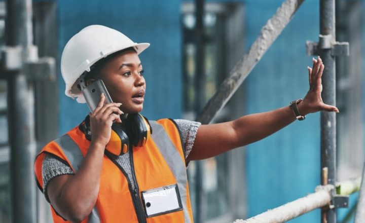 A female construction worker on the phone