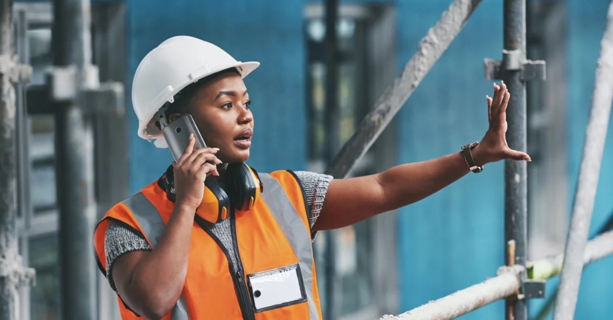 A female construction worker on the phone