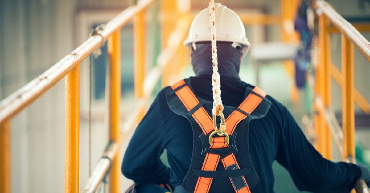 A builder wears a construction safety harness