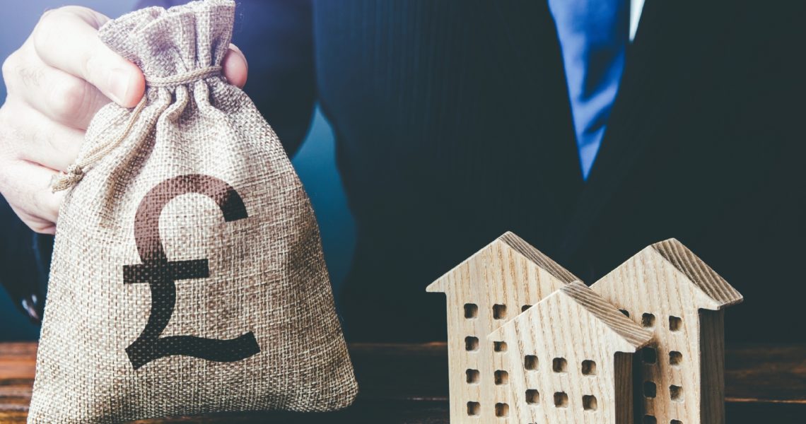 a bag of money beside wooden houses