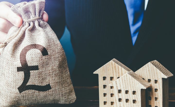 a bag of money beside wooden houses