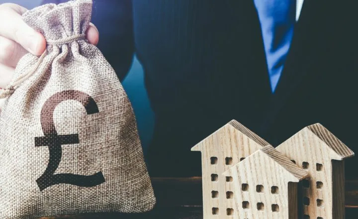 a bag of money beside wooden houses