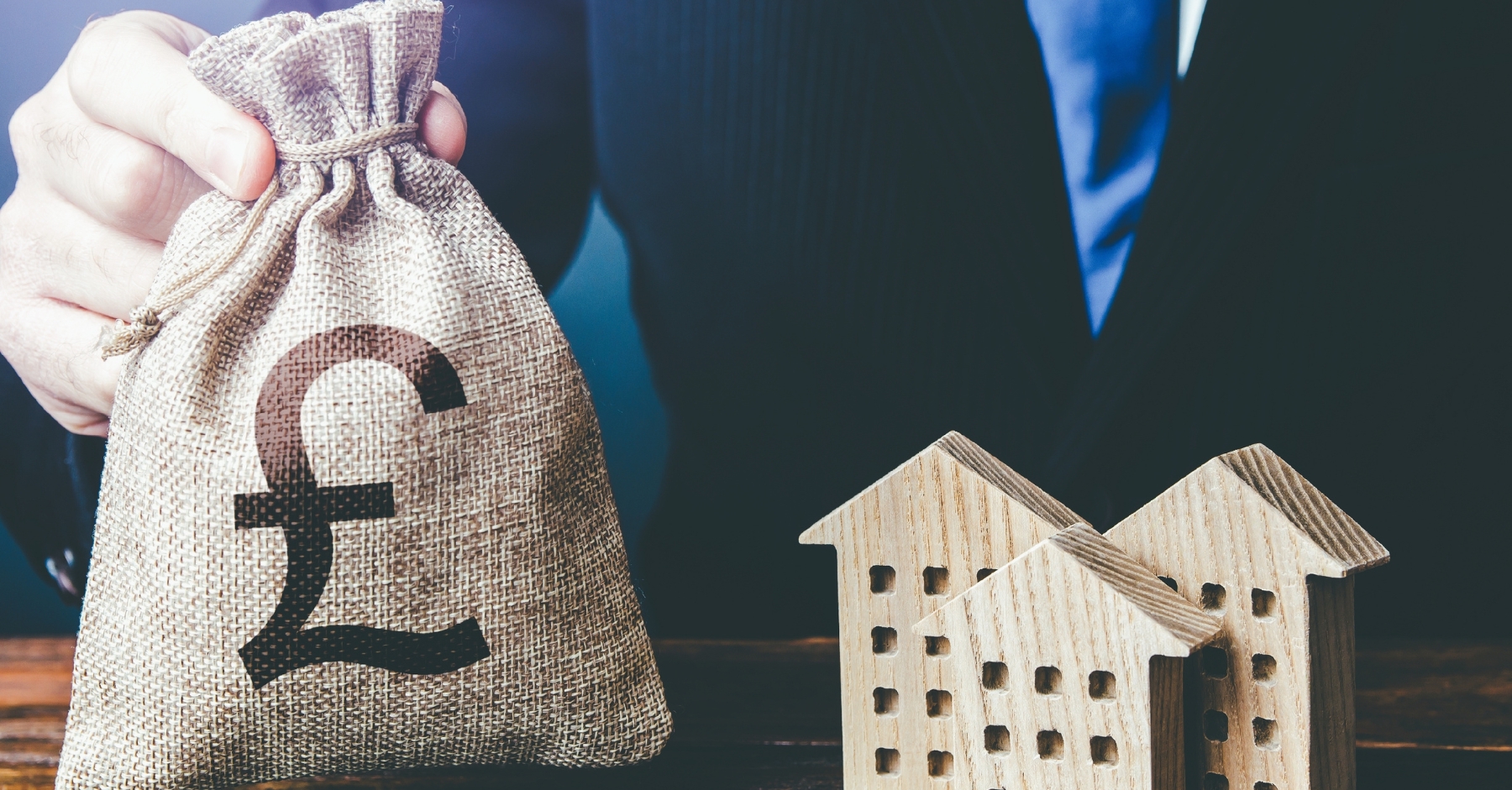 a bag of money beside wooden houses