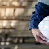 A construction training person holding a white helmet