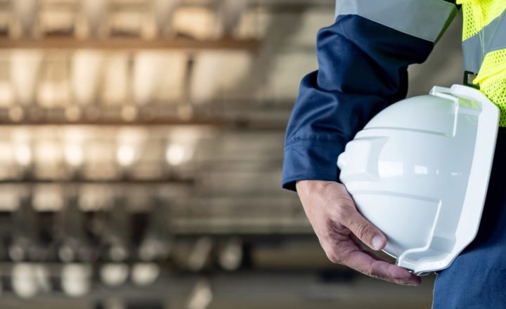 A construction training person holding a white helmet