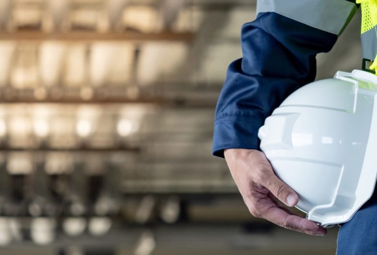 A construction training person holding a white helmet